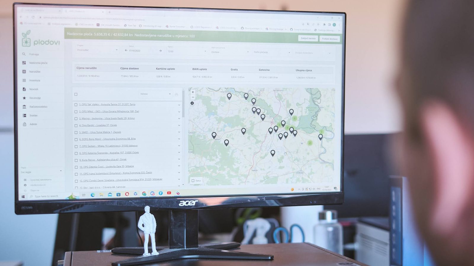 The administrator dashboard on a monitor: a list beside a map pinned with locations across the region.